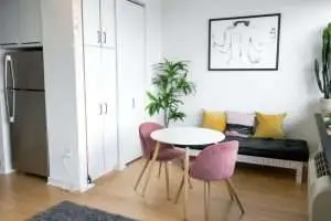 a room with pink tufted chairs.