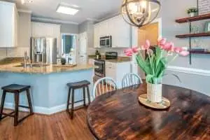 a kitchen with a wooden table and flowers.